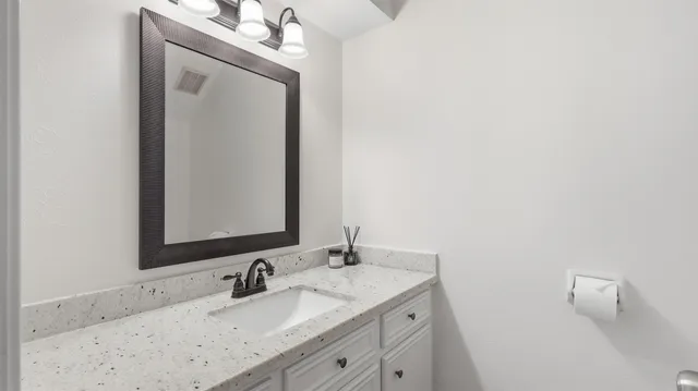 a bathroom with a granite countertop sink vanity and a mirror