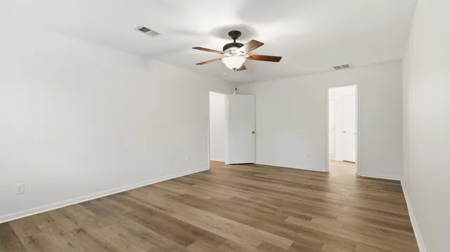 a view of an empty room with wooden floor