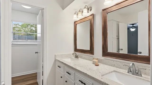 a bathroom with a granite countertop sink and a mirror