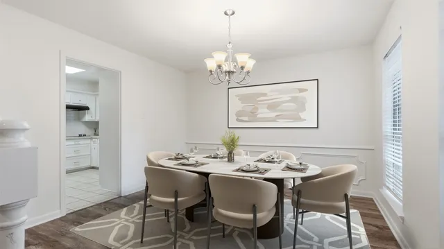 a dining room with furniture a chandelier and wooden floor