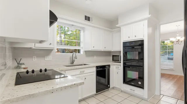 a kitchen with stainless steel appliances kitchen island granite countertop a refrigerator and a sink