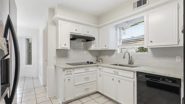 a kitchen with white cabinets and a sink