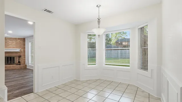 a view of an empty room with window and cabinet