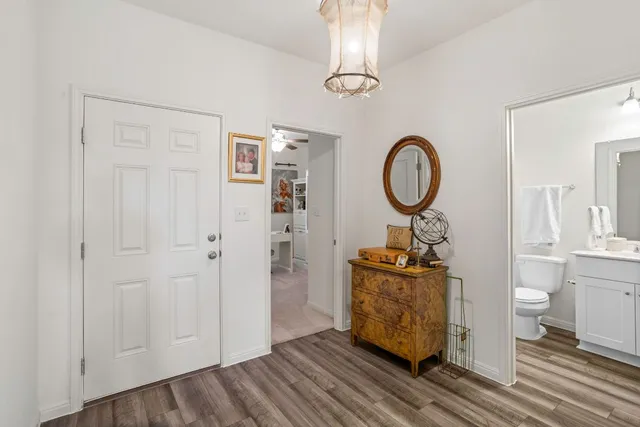 a dining room with wooden floor a glass table and chairs
