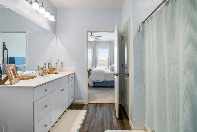 a spacious bathroom with a double vanity sink toilet and a mirror