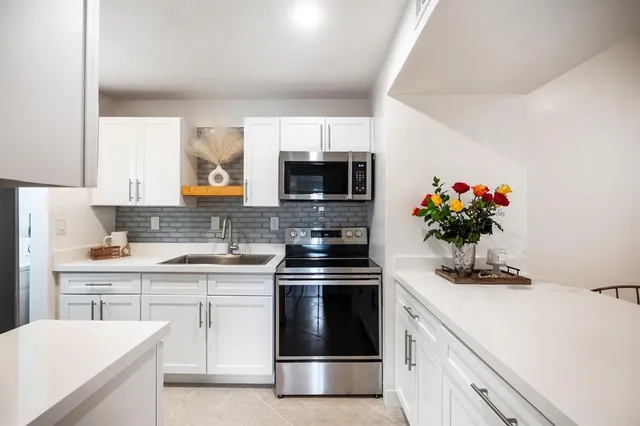 a kitchen with a stove and a white cabinets
