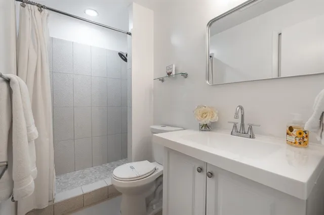 a bathroom with a sink a toilet and shower