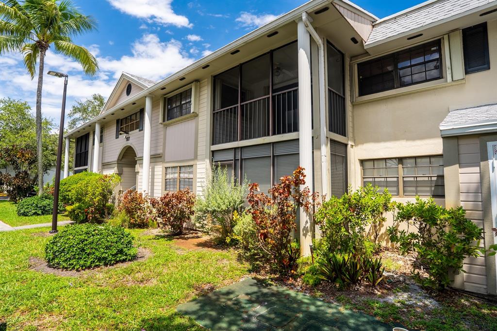 927 Northeast 199th Street, Unit 202 Miami, FL 33179 - Photo 18 of 39 a front view of a house with a yard