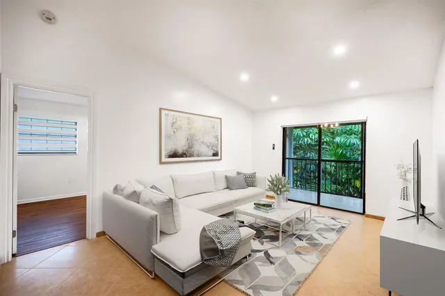 a living room with furniture large window and a flat screen tv