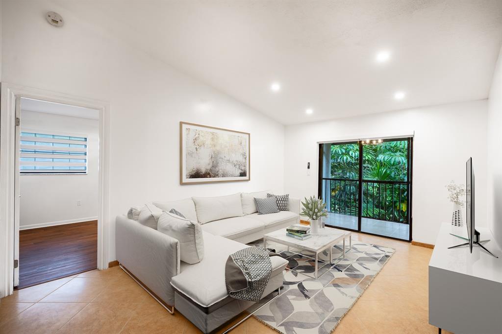 927 Northeast 199th Street, Unit 202 Miami, FL 33179 - Photo 2 of 39 a living room with furniture large window and a flat screen tv