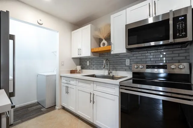 a kitchen with a sink dishwasher stove and cabinets