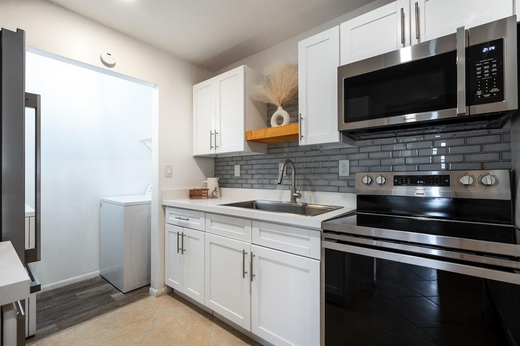 927 Northeast 199th Street, Unit 202 Miami, FL 33179 - Photo 23 of 39 a kitchen with a sink stove and microwave