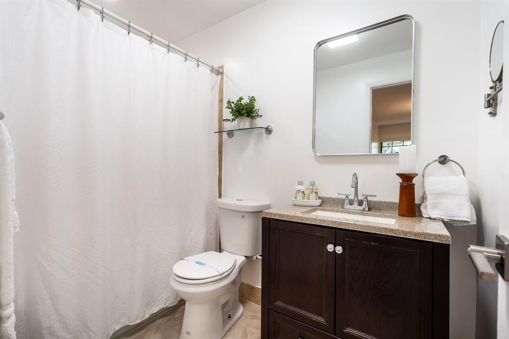 927 Northeast 199th Street, Unit 202 Miami, FL 33179 - Photo 29 of 39 a bathroom with a granite countertop sink toilet and mirror