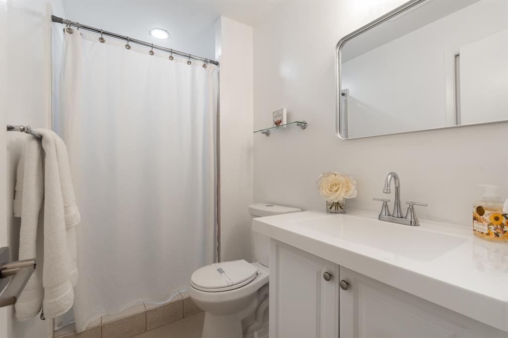 927 Northeast 199th Street, Unit 202 Miami, FL 33179 - Photo 35 of 39 a bathroom with a sink a toilet and shower