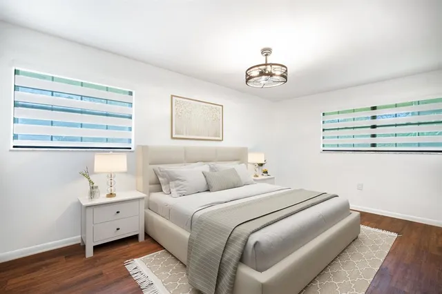 a bedroom with a large bed and a chandelier