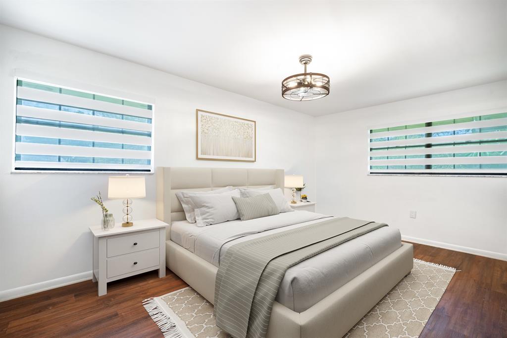 927 Northeast 199th Street, Unit 202 Miami, FL 33179 - Photo 4 of 39 a bedroom with a large bed and a chandelier