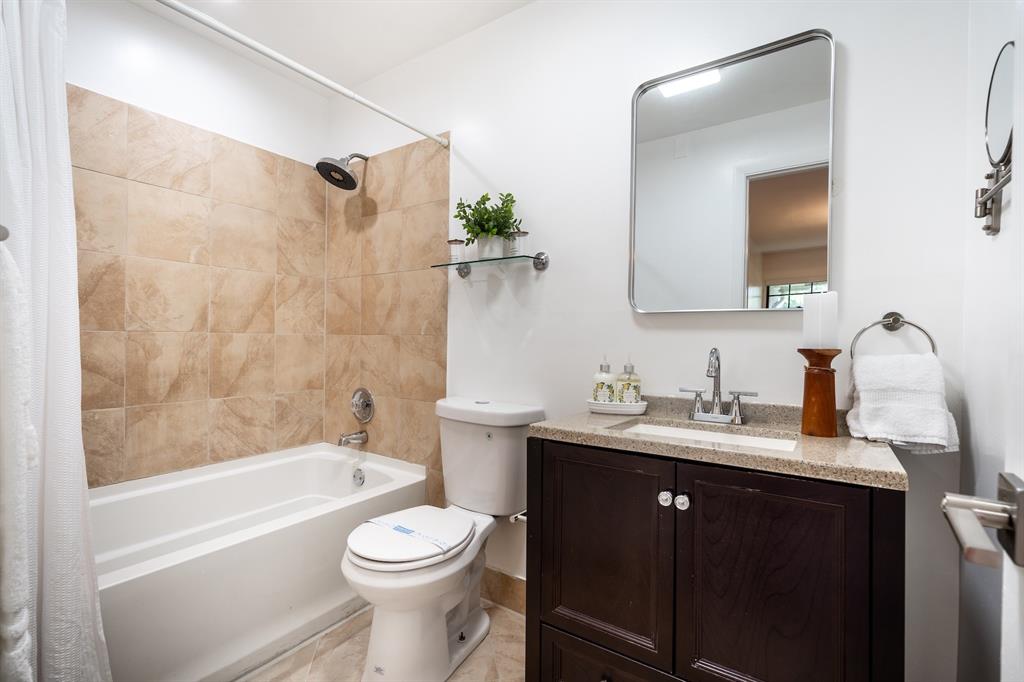 927 Northeast 199th Street, Unit 202 Miami, FL 33179 - Photo 6 of 39 a bathroom with a granite countertop sink toilet and shower