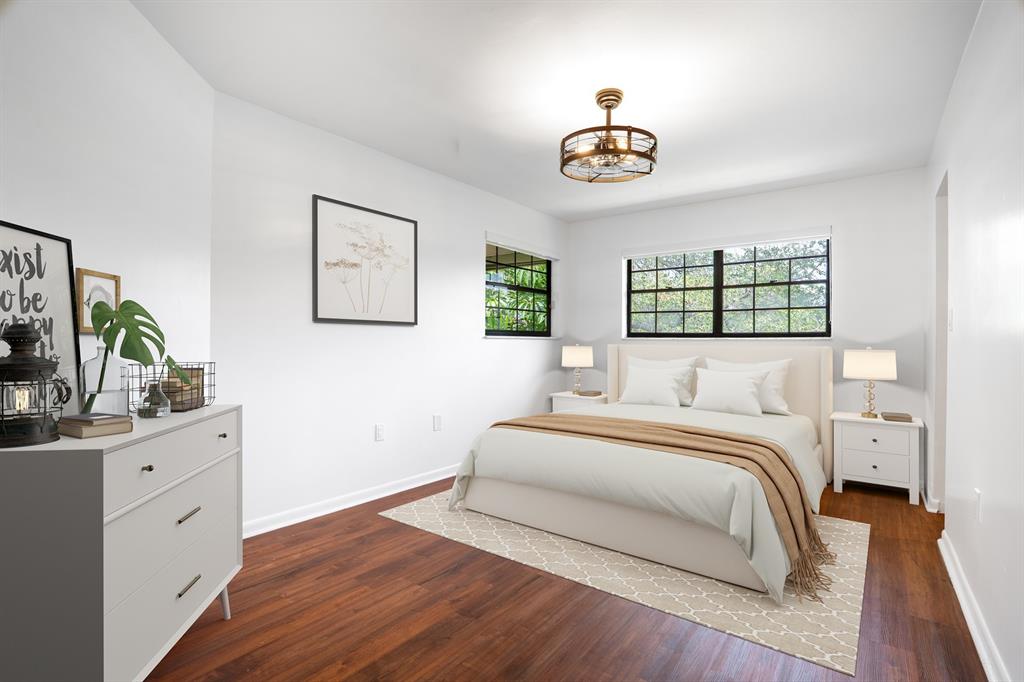 927 Northeast 199th Street, Unit 202 Miami, FL 33179 - Photo 7 of 39 a bedroom with a bed and a chandelier