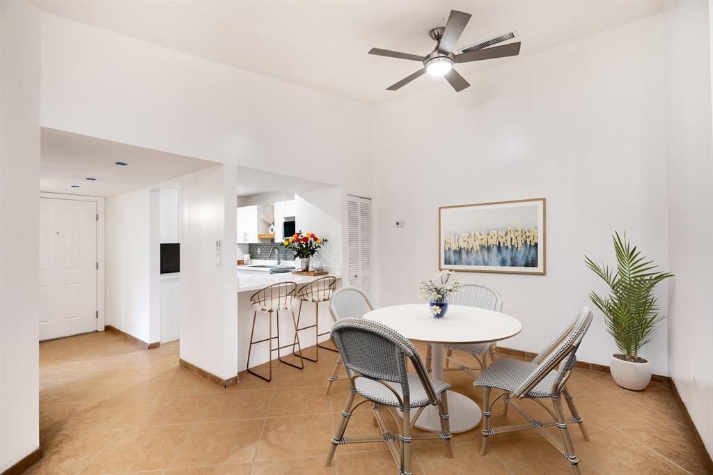 927 Northeast 199th Street, Unit 202 Miami, FL 33179 - Photo 9 of 39 a dining room with furniture and a chandelier fan
