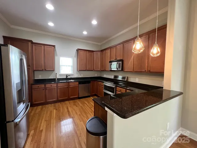 a kitchen with granite countertop a sink a counter space stainless steel appliances and cabinets