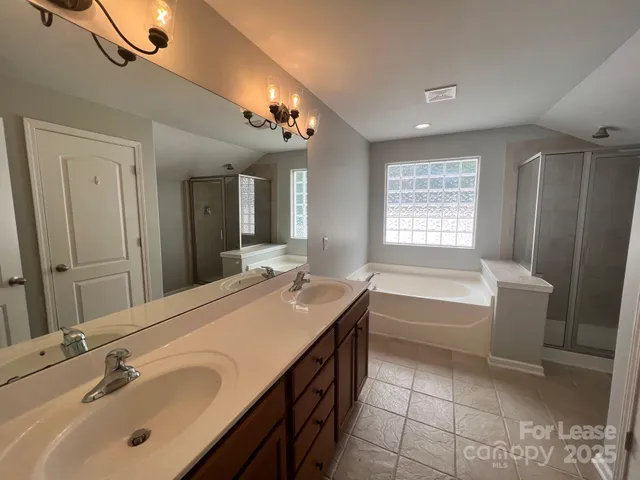 a bathroom with a tub sink and mirror