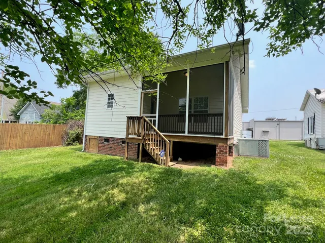 a view of a house with backyard and a tree