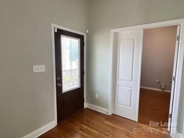 an empty room with wooden floor and a window