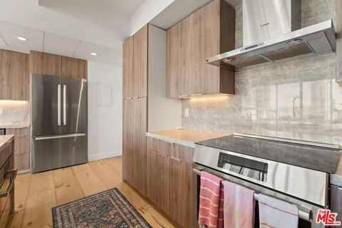 a kitchen with stainless steel appliances granite countertop a refrigerator and a stove
