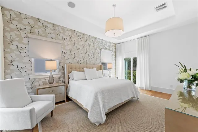 a bedroom with a large bed and a chandelier