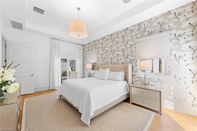 a bedroom with a bed chandelier and a window