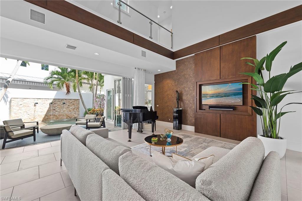 9149 Mercato Way Naples, FL 34108 - Photo 2 of 39 a living room with furniture and a flat screen tv