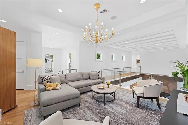 a living room with furniture a chandelier and a rug