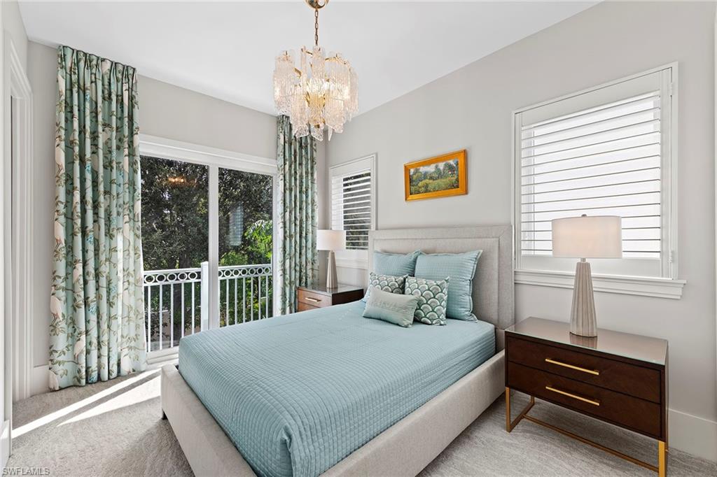 9149 Mercato Way Naples, FL 34108 - Photo 23 of 39 a bedroom with a large bed and a chandelier next to a window