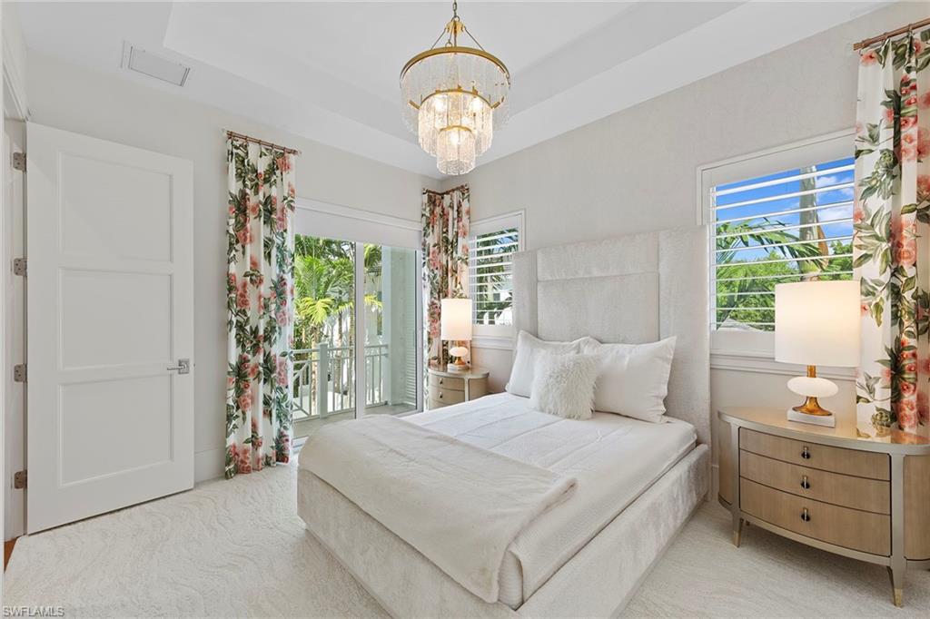 9149 Mercato Way Naples, FL 34108 - Photo 26 of 39 a bedroom with a bed and a chandelier