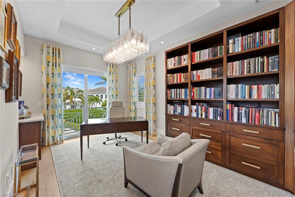 9149 Mercato Way Naples, FL 34108 - Photo 30 of 39 a living room with fireplace furniture and a book shelf