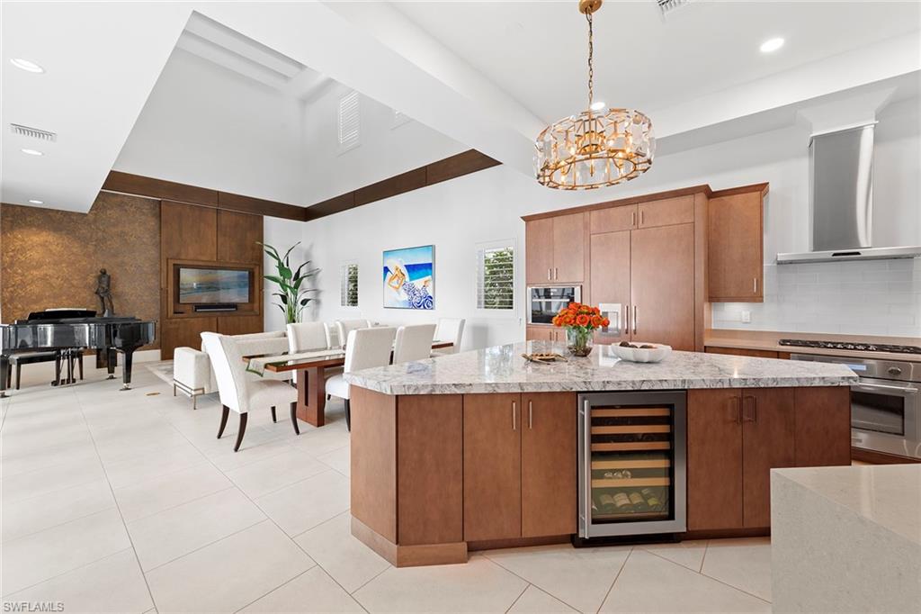 9149 Mercato Way Naples, FL 34108 - Photo 6 of 39 a kitchen with a dining table chairs and a refrigerator