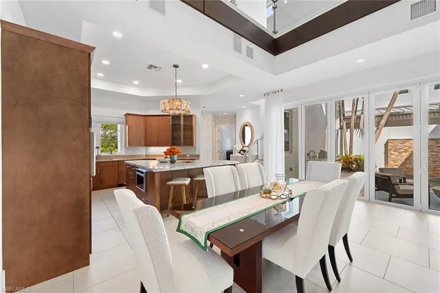a living room with stainless steel appliances furniture and a kitchen view