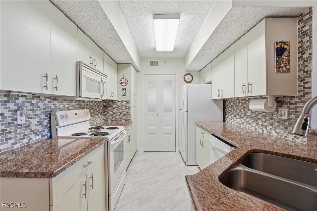 13581 Eagle Ridge Drive, Unit 1434 Fort Myers, FL 33912 - Photo 13 of 45 a kitchen with stainless steel appliances granite countertop a sink and a stove