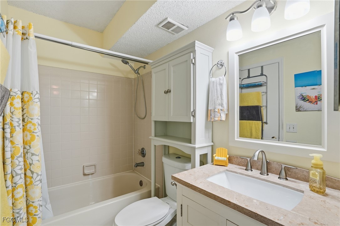 13581 Eagle Ridge Drive, Unit 1434 Fort Myers, FL 33912 - Photo 17 of 45 a bathroom with a granite countertop tub sink toilet and mirror