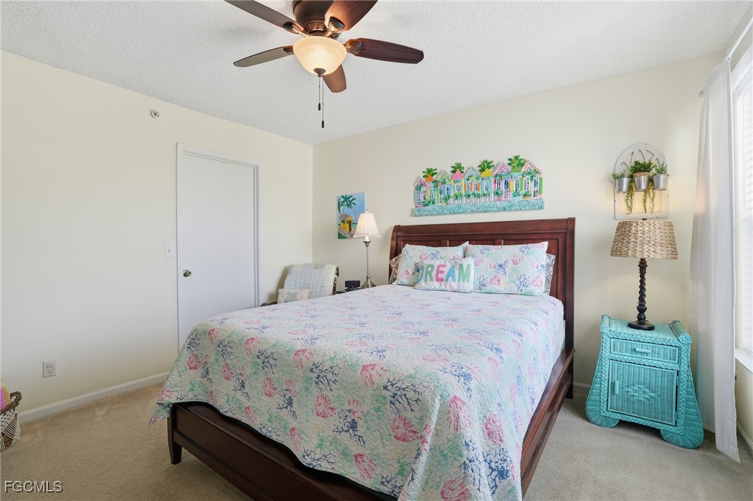 13581 Eagle Ridge Drive, Unit 1434 Fort Myers, FL 33912 - Photo 18 of 45 a bedroom with a bed and a chandelier