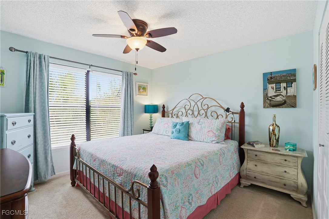 13581 Eagle Ridge Drive, Unit 1434 Fort Myers, FL 33912 - Photo 21 of 45 a bedroom with a bed a chandelier and a window