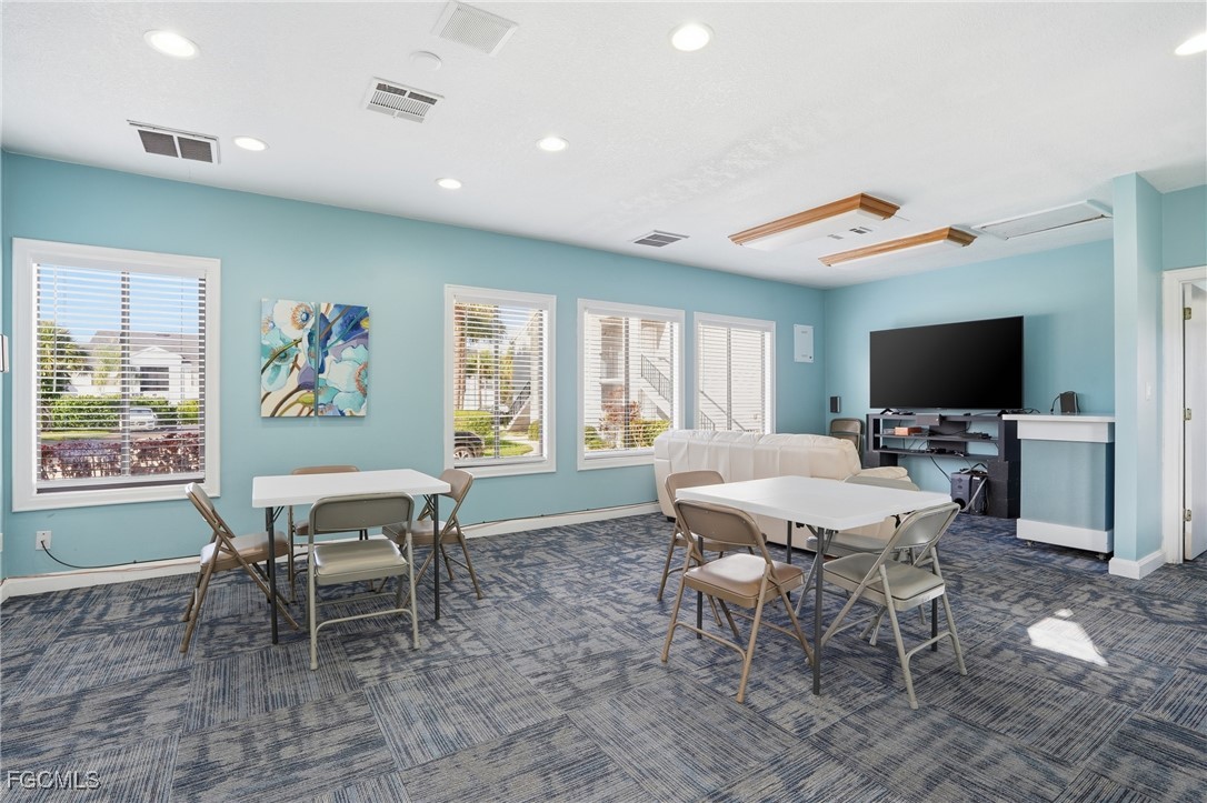 13581 Eagle Ridge Drive, Unit 1434 Fort Myers, FL 33912 - Photo 37 of 45 a living room with furniture a flat screen tv and a dining table