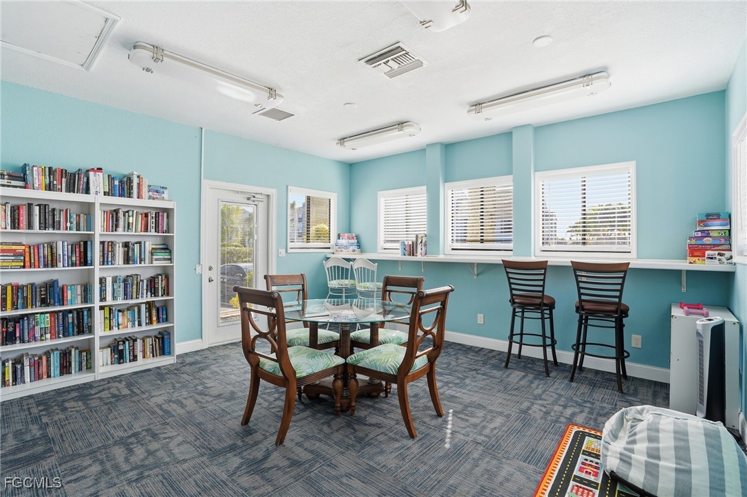 13581 Eagle Ridge Drive, Unit 1434 Fort Myers, FL 33912 - Photo 39 of 45 a dining room with furniture and a book shelf