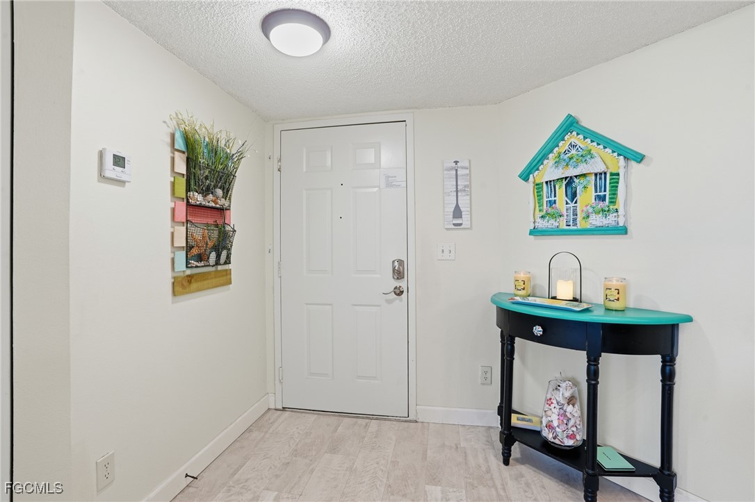 13581 Eagle Ridge Drive, Unit 1434 Fort Myers, FL 33912 - Photo 5 of 45 a view of an entryway with table and front door
