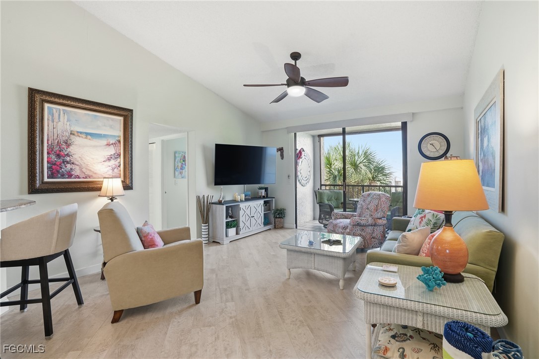 13581 Eagle Ridge Drive, Unit 1434 Fort Myers, FL 33912 - Photo 8 of 45 a living room with furniture a flat screen tv and a large window