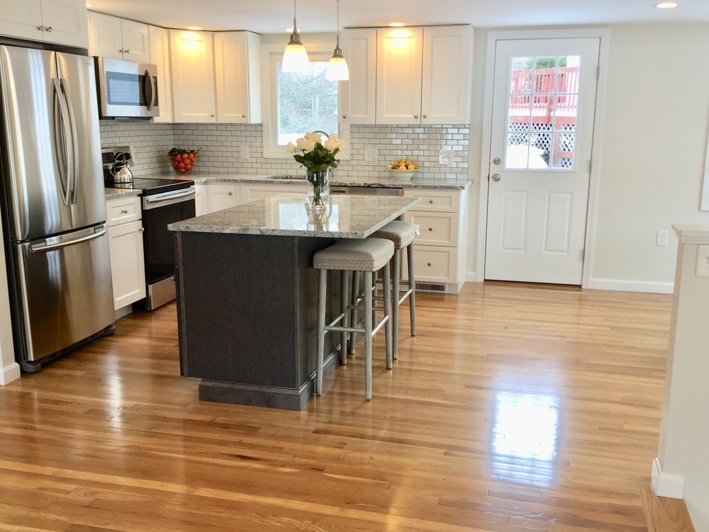 16 Alwin Street Boston, MA 02136 - Photo 9 of 19 a kitchen with kitchen island granite countertop wooden floors and stainless steel appliances