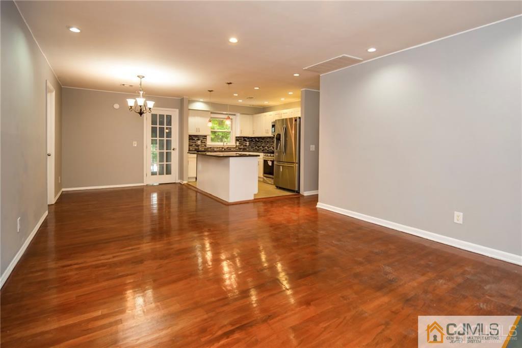 396 Chain O' Hills Road Colonia, NJ 07067 - Photo 3 of 29 a view of a big room with wooden floor and a kitchen