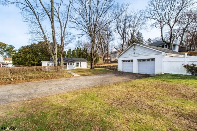 a front view of a house with a yard covered with trees
