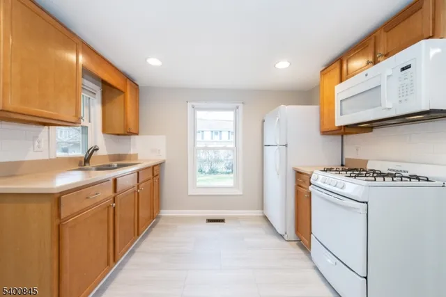 a kitchen with granite countertop a sink stove and refrigerator