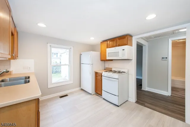 a kitchen with a stove a refrigerator and a sink